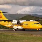 Avion jaune stationné sur une piste d’atterrissage, prêt pour le décollage sous un ciel dégagé – transport aérien léger et aviation de loisir.